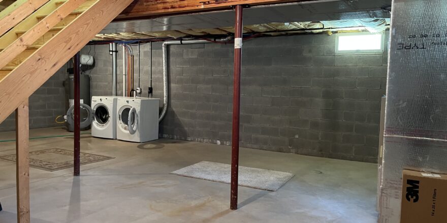 an unfinished basement with washer and dryer