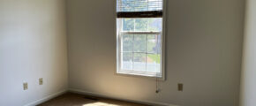 an empty room with a window and blinds