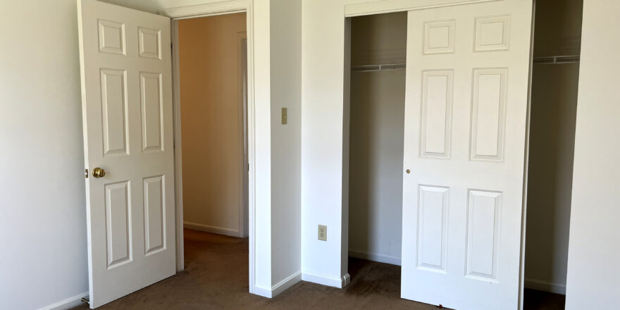 an empty bedroom with a spacious closet