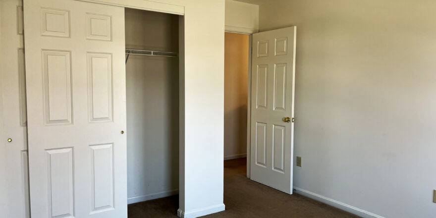 an empty bedroom with a spacious closet