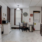 downstairs unit kitchen with white appliances and dark wooden cabinets