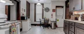 downstairs unit kitchen with white appliances and dark wooden cabinets