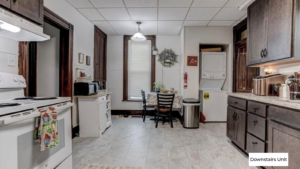 downstairs unit kitchen with white appliances and dark wooden cabinets