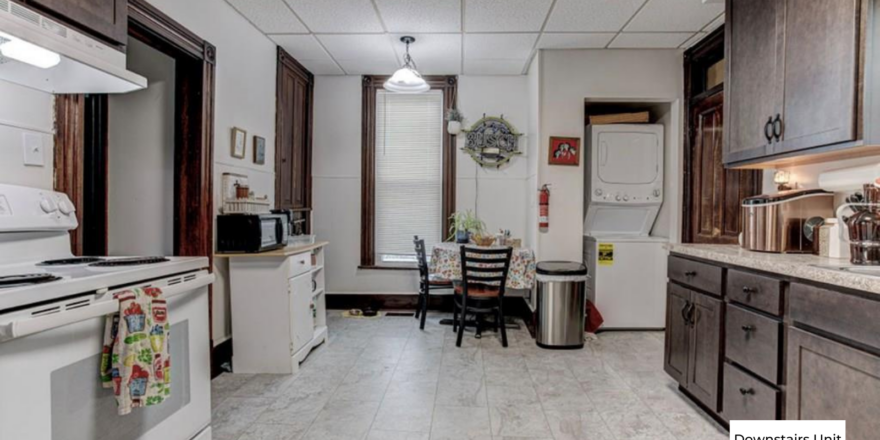 downstairs unit kitchen with white appliances and dark wooden cabinets