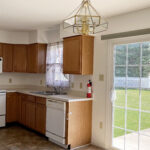 Closer view of kitchen appliances and sliding glass door to the backyard