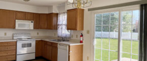 Closer view of kitchen appliances and sliding glass door to the backyard