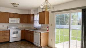 Closer view of kitchen appliances and sliding glass door to the backyard