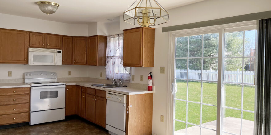 Closer view of kitchen appliances and sliding glass door to the backyard