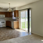 View of kitchen with a stove, microwave, dishwasher, counter, and sliding glass door to backyard
