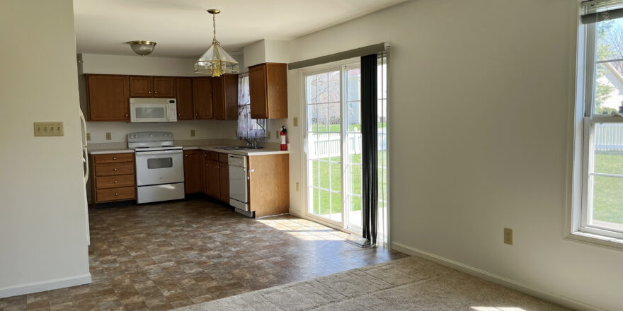 View of kitchen with a stove, microwave, dishwasher, counter, and sliding glass door to backyard