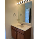 a bathroom with a sink, mirror and lights