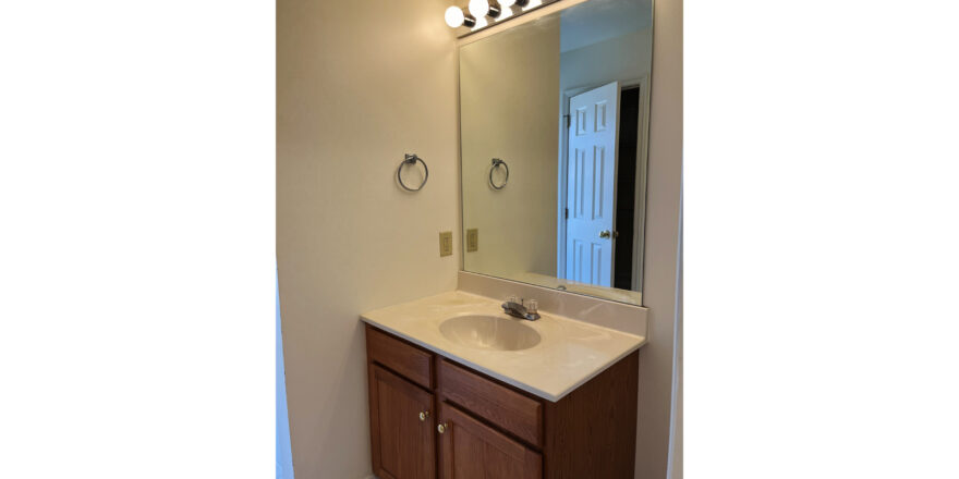 a bathroom with a sink, mirror and lights