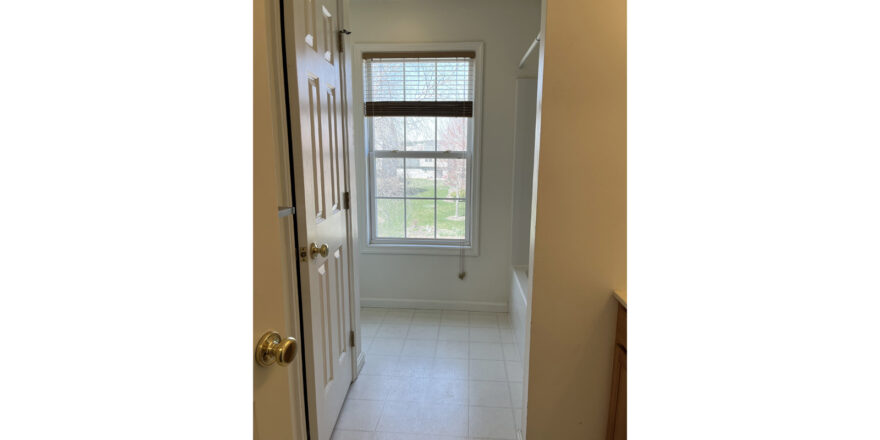 a hallway leading to bathroom window