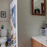 upstairs unit bathroom with a toilet, sink and mirror