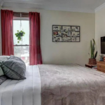 upstairs unit 1st bedroom with a neatly made bed and white walls