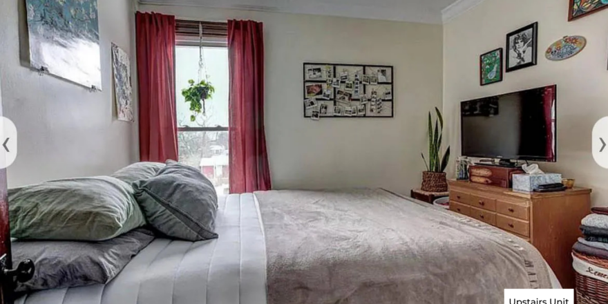 upstairs unit 1st bedroom with a neatly made bed and white walls