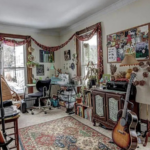 upstairs unit second bedroom with white walls, two windows on each exterior facing wall, and light carpeting