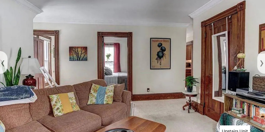 upstairs unit living room with white walls and light carpeting