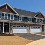 a row of houses with a two-car garage on each side