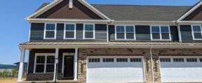 a large house with a two-car garage, five windows, and a covered entry