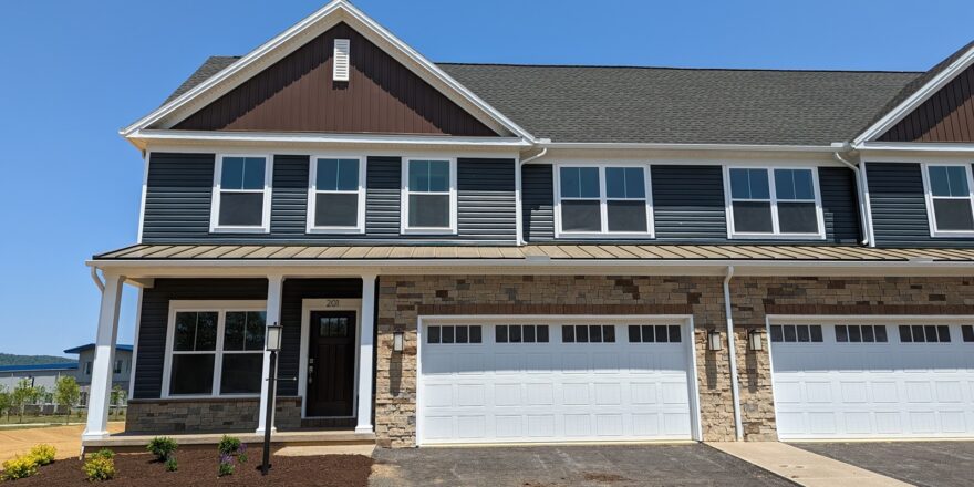 a large house with a two-car garage, five windows, and a covered entry