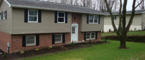 a two story house with black shutters on the windows