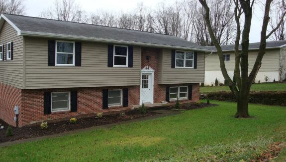 a two story house with black shutters on the windows