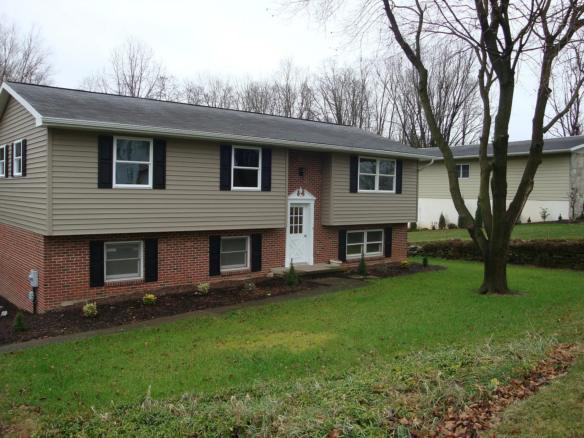 a two story house with black shutters on the windows