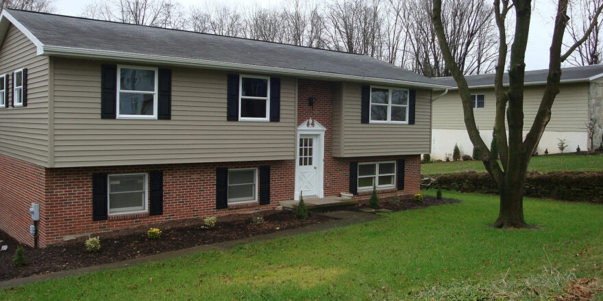 a two story house with black shutters on the windows