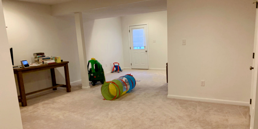 a carpeted basement with outside entry