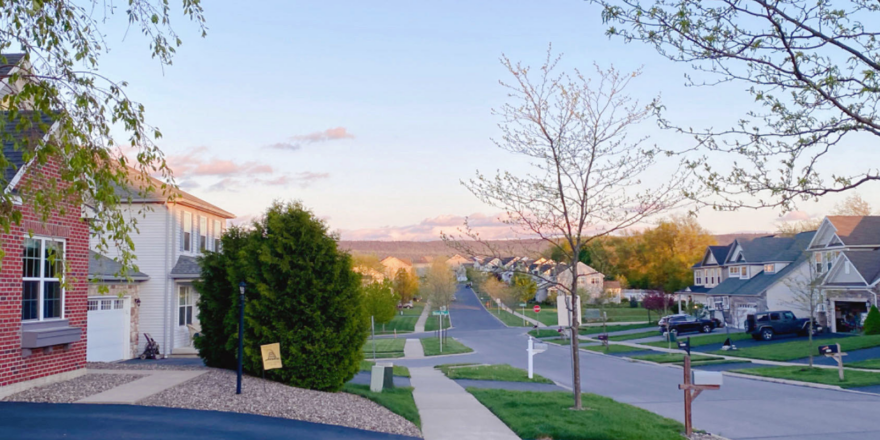 a street with houses and mountains in the distance