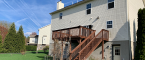 back exterior of house with a wooden staircase leading up to the deck