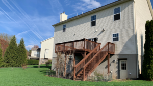 back exterior of house with a wooden staircase leading up to the deck