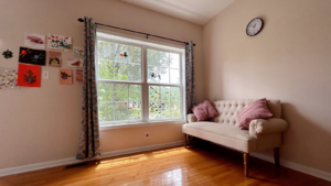 a office room with a couch and a clock on the wall