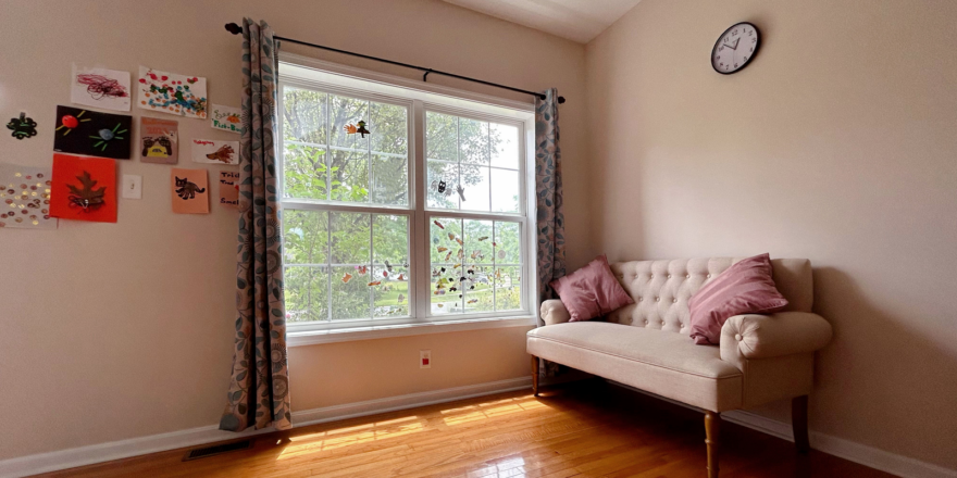 a office room with a couch and a clock on the wall