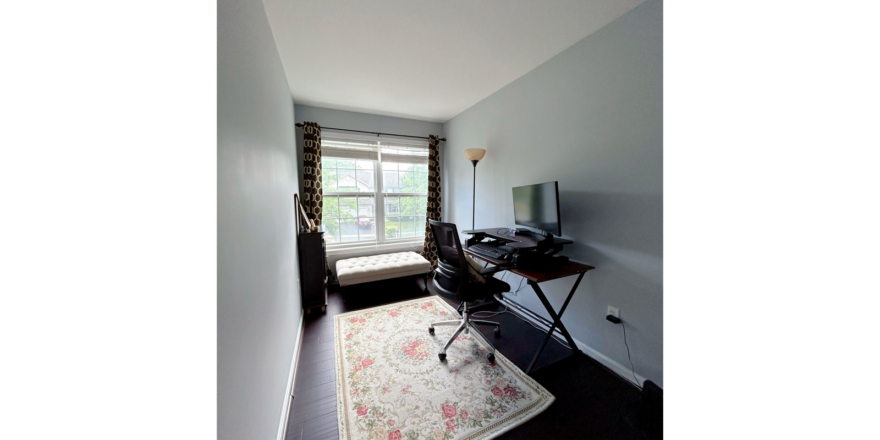 a room with a desk, chair, and window