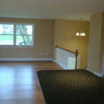 an empty living room with hard wood floors