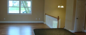 an empty living room with hard wood floors