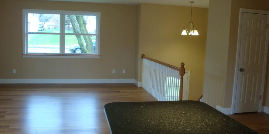 an empty living room with hard wood floors