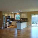an empty kitchen and living room with wood floors