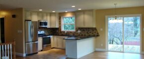 an empty kitchen and living room with wood floors