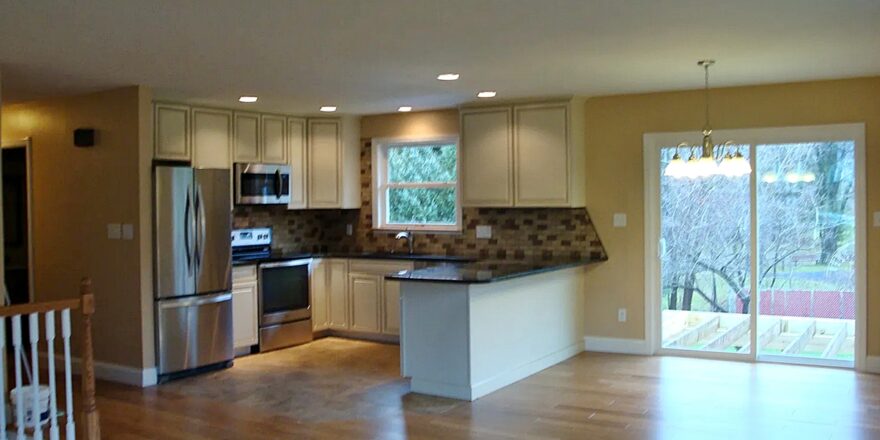 an empty kitchen and living room with wood floors