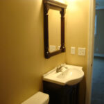 a bathroom with a sink, mirror and toilet