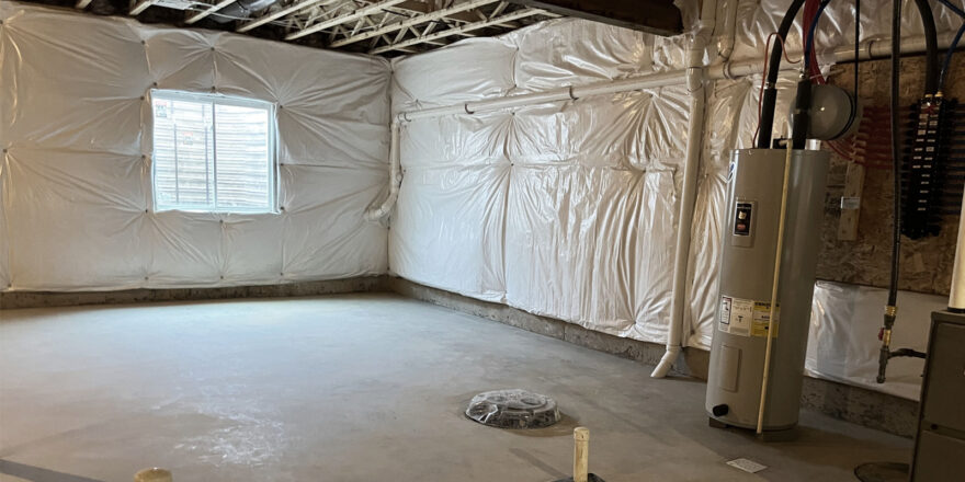 an unfinished basement with white tarps covering the walls