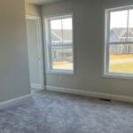an empty room with two windows in it
