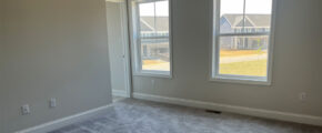 an empty room with two windows in it