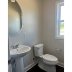 a white toilet sitting next to a sink in a bathroom