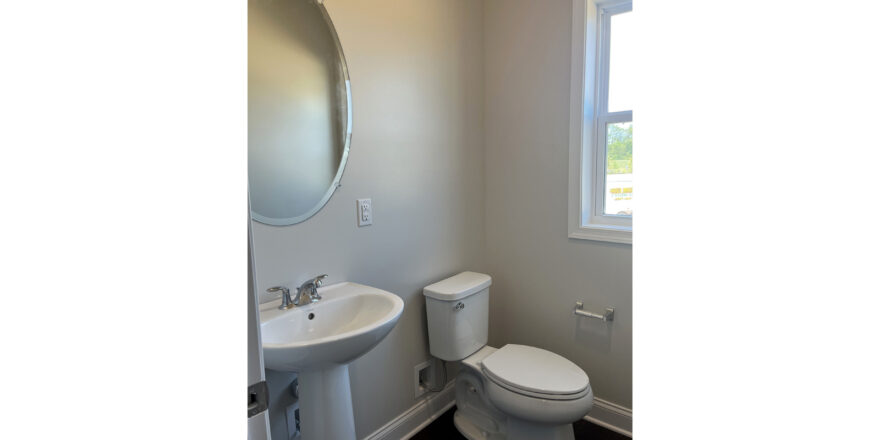 a white toilet sitting next to a sink in a bathroom