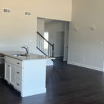 an empty kitchen and living room with hardwood floors