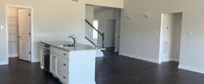 an empty kitchen and living room with hardwood floors